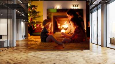 Happy family by a fireplace on Christmas Wall mural