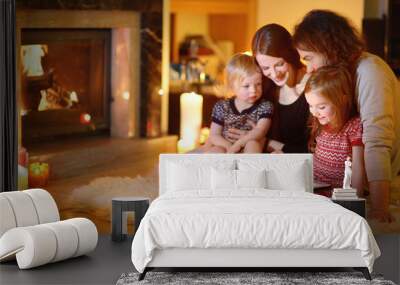 happy family using a tablet pc by a fireplace Wall mural