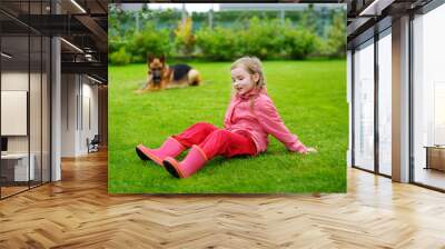 Happy little girl playing with a big dog Wall mural