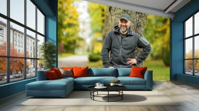 Portrait of an attractive middle age man in beautiful autumn park. Wall mural