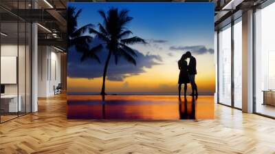 Silhouettes of young couple at scenic sunset Wall mural