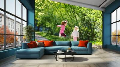 Two adorable little sisters laughing and jumping Wall mural