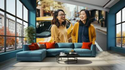 Two cheerful female friends going on a road trip together. Two beautiful women ready to ride a car. Girls night out. Wall mural