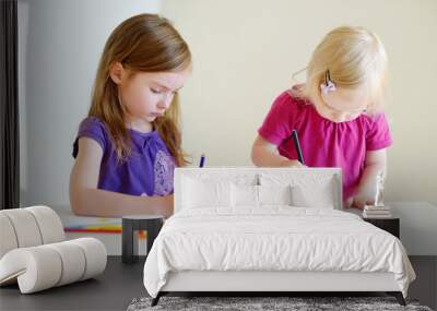 Two little sisters drawing with colorful pencils Wall mural