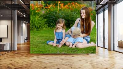 Young mother and her two little daughters Wall mural