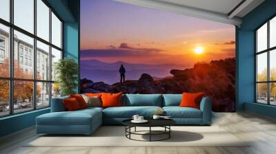 Tourist watching sunset in the mountains Wall mural