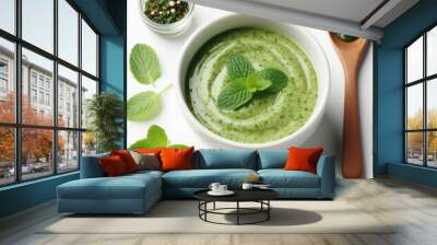 Bowl of spicy green mint pesto sauce isolated on a white background  Wall mural