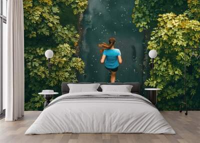 Top view of young sporty woman running in a city park  Wall mural