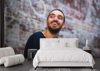 Handsome smiling and casual young man looking towards Wall mural