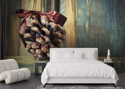 The cone of a coniferous tree with a brown bow on wooden texture Wall mural