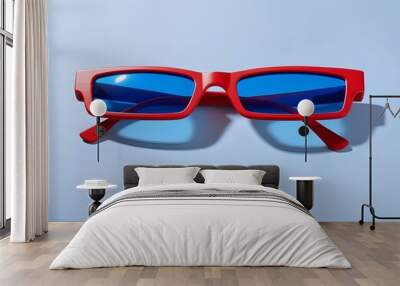 A pair of red rectangular sunglasses with blue lenses against a light blue background Wall mural