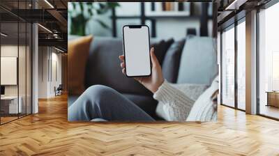 Side view Woman sitting on minimalist sofa and holding blank screen mock up mobile phone, Ai generated images Wall mural