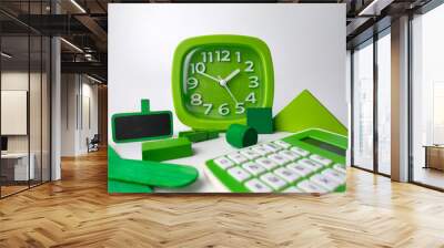 Close-up shot of a green alarm clock, calculator, and geometric shapes on a white background Wall mural