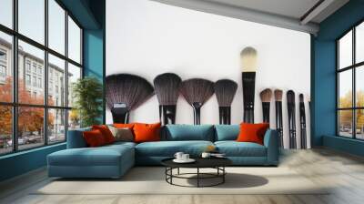 A set of a black make up brushes over the white background Wall mural