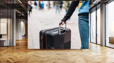 Traveler carrying suitcase luggage at outdoor destination.. Wall mural