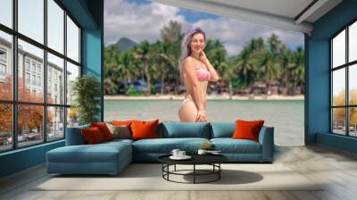 beautiful girl on a paradise green island. Slender girl on the beach. Girl with purple hair in a swimsuit. Happy girl on vacation. A woman with a beautiful slim body on the beach in a swimsuit. Sexy Wall mural