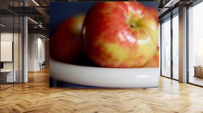 Red apples in a blue and white striped bowl on a blue background Wall mural