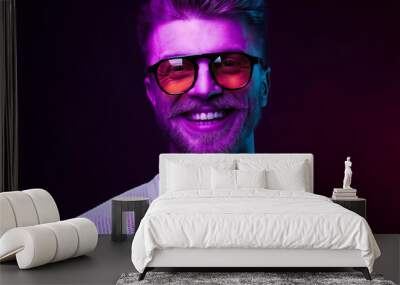 neon light portrait of smiling man model with mustaches and beard in orange sunglasses and white t-s Wall mural