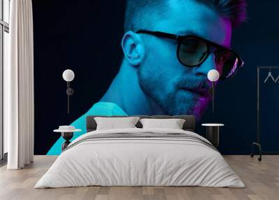 Neon light studio close-up portrait of attractive male model in sunglasses and white t-shirt Wall mural