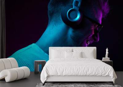 Neon portrait of bearded smiling man in headphones, sunglasses, white t-shirt. Listening to music Wall mural