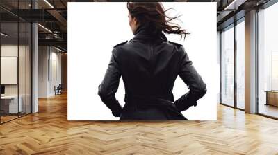 Mysterious brunette in a sleek black trench coat, captured mid-stride, exuding an aura of intrigue and allure against a white backdrop. Wall mural