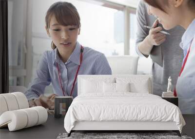 Two young women are to work with the tablet Wall mural