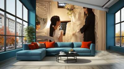 ドレスを見ながら楽しそうに話す新婦とウエディングプランナー Wall mural