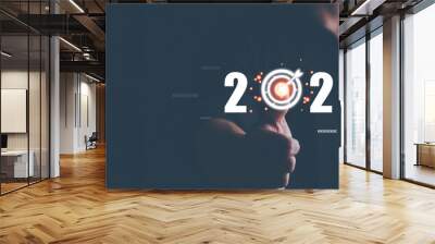 Businessman's finger pressing starting up 2023 button on virtual interface on black background with copy space for text. New year, new job, start up business. Beginning of New Year 2023 concept. Wall mural