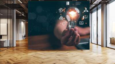 Man holding lightbulb showing graduation hat, Internet education course degree study knowledge to creative thinking idea and problem solving solution. E-learning graduate certificate program concept. Wall mural