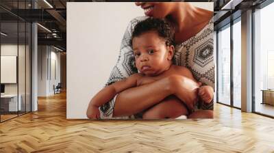 portrait of african american mother holding her baby girl, black female cancer patient in healing with chemotherapy holding her baby on hands Wall mural