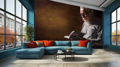 senior old christian man holding and reading holy bible book Wall mural