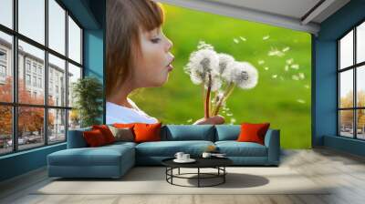 little girl blowing dandelions on the meadow Wall mural