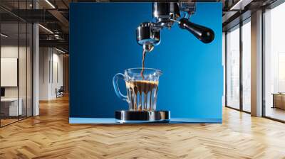 Product photo of a chrome piston coffee maker pouring coffee into a glass, on a dark blue background Wall mural