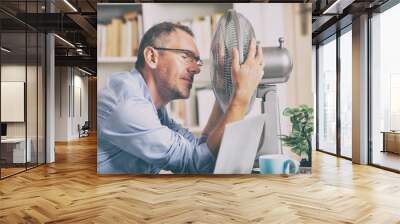 Man suffers from heat in the office or at home Wall mural