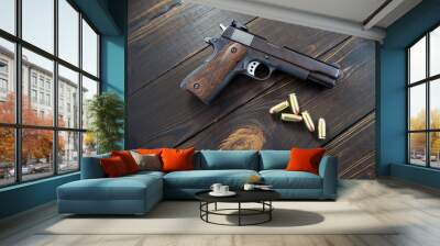 Golden pistol bullets and a gun on a wooden background Wall mural