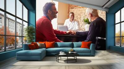 A gay male couple holding hands at a hotel check in desk Wall mural