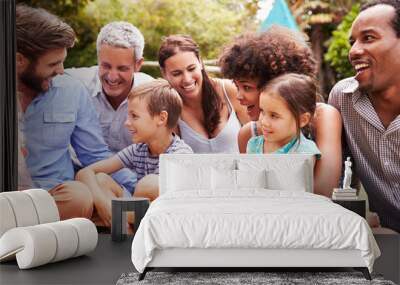 Adults and kids sitting on the grass in a garden Wall mural