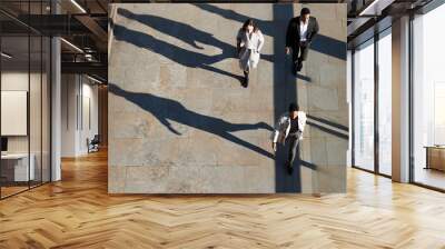 Aerial view of three city workers walking on a sunny urban street, horizontal Wall mural