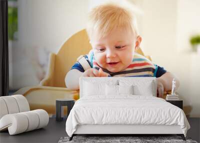 Baby Boy Eating Fruit In High Chair Wall mural