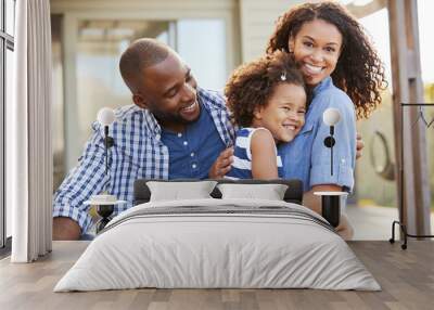 Black family embracing outdoors smiling to camera outside Wall mural