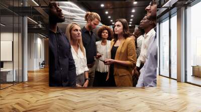 Business people standing in office elevator Wall mural