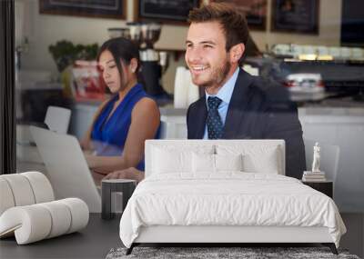 Businessman Using Laptop In Coffee Shop Wall mural