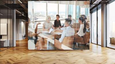 businesswoman leads meeting around table shot through door Wall mural