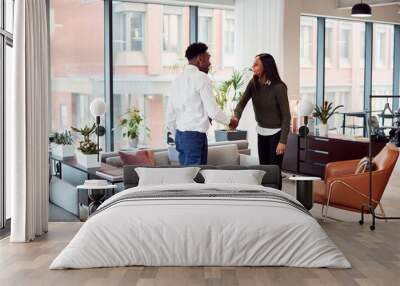 Businesswoman Shaking Hands With Male Interview Candidate In Seating Area Of Modern Office Wall mural