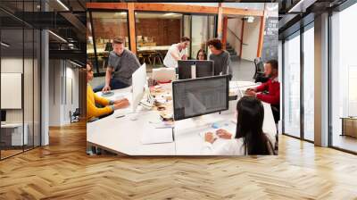 Casually Dressed Business Team Working At Desks In Modern Open Plan Office Wall mural