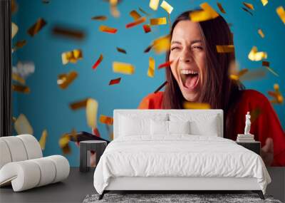 Celebrating Young Woman With Mobile Phone Winning Prize And Showered With Gold Confetti In Studio Wall mural