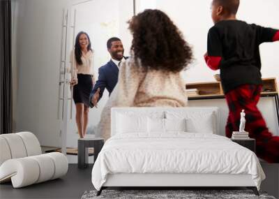 children greeting and hugging working parents as they return home from work Wall mural