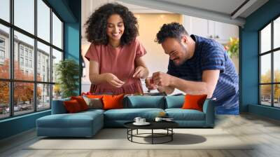 Couple At Home With Man With Down Syndrome And Woman Putting Toppings On Pizza In Kitchen Together Wall mural