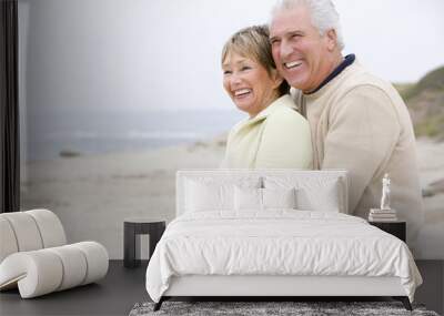 Couple at the beach embracing and smiling Wall mural