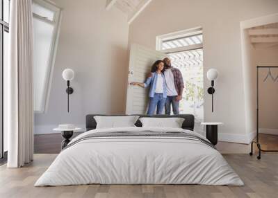 Couple Opening Door And Walking In Empty Lounge Of New Home Wall mural